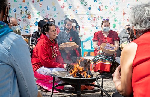 JESSICA LEE / WINNIPEG FREE PRESS

Aja Oliver (at fire) is photographed at North End Womens Centre on May 5, 2022 for Red Dress Day. Community members gathered to sing healing songs for the afternoon.

