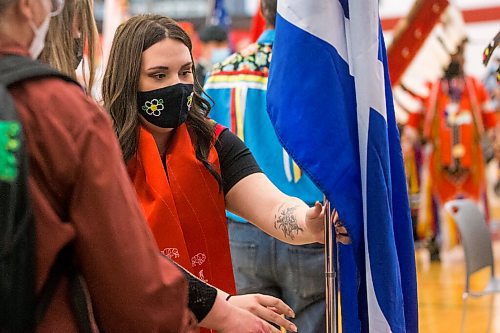 MIKAELA MACKENZIE / WINNIPEG FREE PRESS

Kyra De La Ronde places the Metis flag in its holder during the RRC Polytech graduation Pow Wow in Winnipeg on Friday, May 6, 2022. For Malak Abas story.
Winnipeg Free Press 2022.