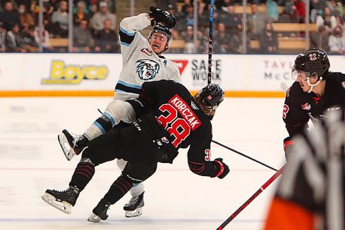 Daniel Crump / Winnipeg Free Press. Moosejaw Warriors center Ryder Korczak (38) is punished with a big hit from a Winnipeg Ice player during the third period of game one of the second round playoff series at Wayne Fleming Arena in Winnipeg. May 6, 2022.