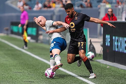 Daniel Crump / Winnipeg Free Press. Halifax Wanderers Jérémy Gagnon-Laparé (28) and Valour FC Federico Rafael Peña  (77) battle for the ball along the line during Valours home opener at IG Field in Winnipeg. May 7, 2022.