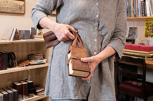 JESSICA LEE / WINNIPEG FREE PRESS

Deb Frances, a book artist, demonstrates how a leather book belt would be worn on May 9, 2022 in her home studio.

Reporter: Brenda Suderman


