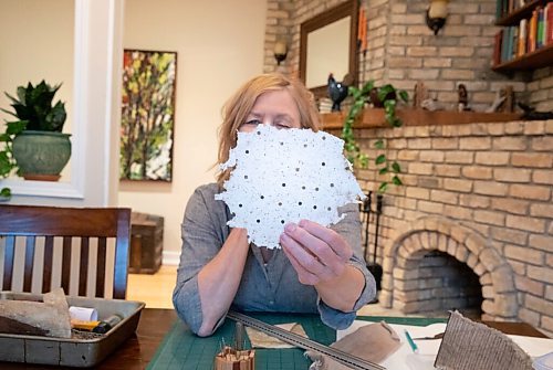 JESSICA LEE / WINNIPEG FREE PRESS

Deb Frances, a book artist, holds up a piece of paper she made with fish scales in her dining room with her materials on May 9, 2022.

Reporter: Brenda Suderman

