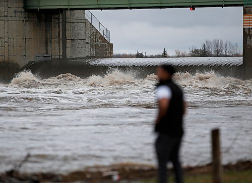 JOHN WOODS / WINNIPEG FREE PRESS
A man looks on as water rushes through a raised floodway gate just south of St Norbert Monday, August 9, 2021.