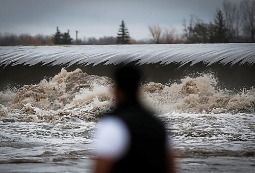 JOHN WOODS / WINNIPEG FREE PRESS
A man looks on as water rushes through a raised floodway gate just south of St Norbert Monday, August 9, 2021.