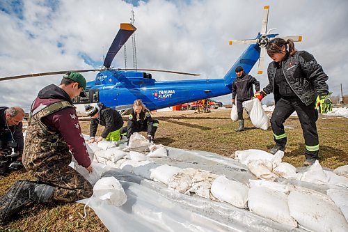 MIKE DEAL / WINNIPEG FREE PRESS
Volunteers and paramedics help build a sandbag dike around the Peguis Emergency Centre and Firehall Tuesday afternoon.
Residents of Peguis FN who have not fled the rising water had a small reprieve Tuesday, which has allowed them to add protection to various locations and attempt to get basements emptied of water. The forecast doesn't look good towards the end of the week with days of rain on the way.
See Malak Abas story
220510 - Tuesday, May 10, 2022.