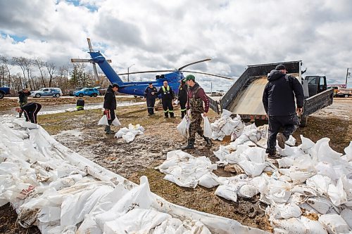 MIKE DEAL / WINNIPEG FREE PRESS
Volunteers and paramedics help build a sandbag dike around the Peguis Emergency Centre and Firehall Tuesday afternoon.
Residents of Peguis FN who have not fled the rising water had a small reprieve Tuesday, which has allowed them to add protection to various locations and attempt to get basements emptied of water. The forecast doesn't look good towards the end of the week with days of rain on the way.
See Malak Abas story
220510 - Tuesday, May 10, 2022.