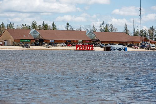 MIKE DEAL / WINNIPEG FREE PRESS
The main shopping centre and band office seems to be sitting at the edge of a lake.
Residents of Peguis FN who have not fled the rising water had a small reprieve Tuesday, which has allowed them to add protection to various locations and attempt to get basements emptied of water. The forecast doesn't look good towards the end of the week with days of rain on the way.
See Malak Abas story
220510 - Tuesday, May 10, 2022.