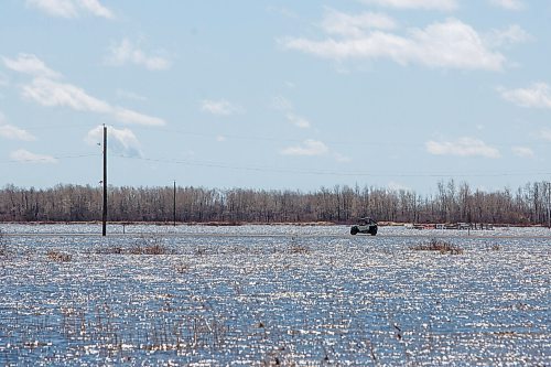 MIKE DEAL / WINNIPEG FREE PRESS
From a distance vehicles seem to be driving on top of the water, but in reality they are just able to follow a narrow ribbon of road sitting inches above the flooded fields.
Residents of Peguis FN who have not fled the rising water had a small reprieve Tuesday, which has allowed them to add protection to various locations and attempt to get basements emptied of water. The forecast doesn't look good towards the end of the week with days of rain on the way.
See Malak Abas story
220510 - Tuesday, May 10, 2022.