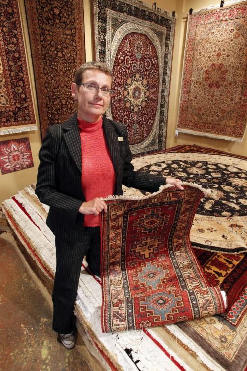 BORIS.MINKEVICH@FREEPRESS.MB.CA  100825 BORIS MINKEVICH / WINNIPEG FREE PRESS Ten Thousand Villages manager Gwen Repeta poses for a photo with some rugs they sell that were made in Pakistan.