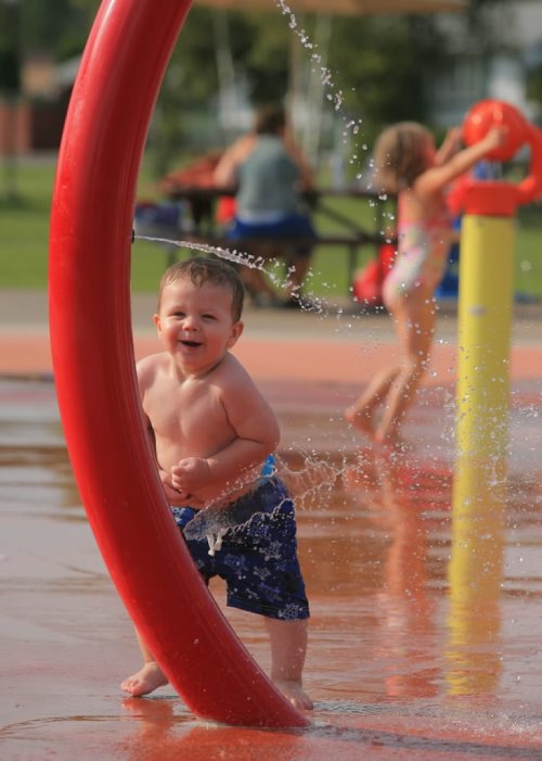 Brandon Sun Sixteen-month-old Liam Osudar reacts to the jet of water spraying out of the nozzles at the spray park on First Street south on Friday afternoon. The city has decided to extend the operations of the spray park. (Bruce Bumstead/Brandon Sun)
