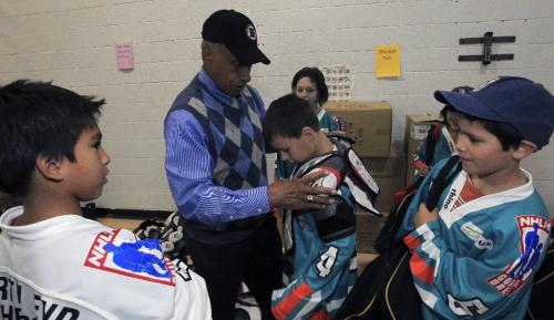 MIKE.DEAL@FREEPRESS.MB.CA 100923 - Thursday, September 23, 2010 -  Willie O'Ree, the first black man to play in the National Hockey League, helps to fit some of the innercity kids with hockey gear. Willie is in town to help kick off the second year of the Hockey Heroes program, a nation-wide initiative where local business guys teach innercity kids how to play hockey and also pay for their equipment. The event took place at Marymound School. MIKE DEAL / WINNIPEG FREE PRESS