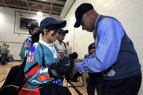 MIKE.DEAL@FREEPRESS.MB.CA 100923 - Thursday, September 23, 2010 -  Taylor Schoffer, 11, gets fitted for hockey gloves by Willie O'Ree, the first black man to play in the National Hockey League. Willie is in town to help kick off the second year of the Hockey Heroes program, a nation-wide initiative where local business guys teach innercity kids how to play hockey and also pay for their equipment. The event took place at Marymound School. MIKE DEAL / WINNIPEG FREE PRESS