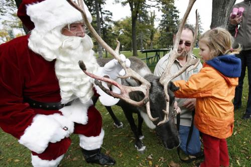 September 23, 2010 - 100923  - September 23, 2010 - 100923  - Santa, Pippa Hlannon (4) and zoo keeper Mike Nocei pet a reindeer prior to a press conference to announce the Winnipeg Santa Claus Parade. Santa made a visit to Assiniboine Park today Thursday, September 23, 2010 to announce the upcoming Winnipeg Santa Claus Parade on November 13.    John Woods / Winnipeg Free Press