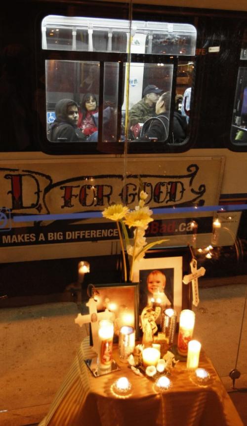BORIS.MINKEVICH@FREEPRESS.MB.CA  100928 BORIS MINKEVICH / WINNIPEG FREE PRESS A vigil in the memory of murder victim Darren Walsh at the corner of Euclid St. Avenue and Main Street. A bus passes by at the stop where Walsh was gunned down.