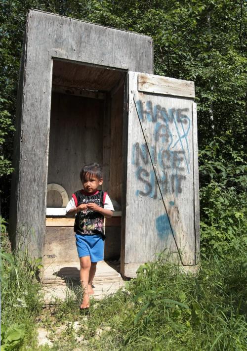 JOE.BRYKSA@FREEPRESS.MB.CA NO RUNNING WATER FEATURE-(See Helen's story)  -  A youngster walks out of an outhouse on St.Theresa Point First Nation. The family has no running water. - July , 2010, - JOE BRYKSA/WINNIPEG FREE PRESS