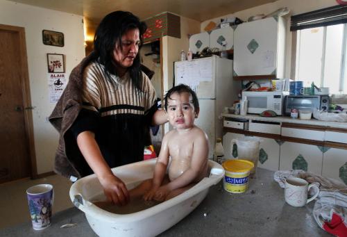 JOE.BRYKSA@FREEPRESS.MB.CA NO RUNNING WATER FEATURE-(See Helen's story)  -   Mother Rose Rae  washes her baby Lucas Rae on the kitchen table at their home in  St.Theresa Point First Nation - The family has no bath tub or running water in their home  March2010, - JOE BRYKSA/WINNIPEG FREE PRESS