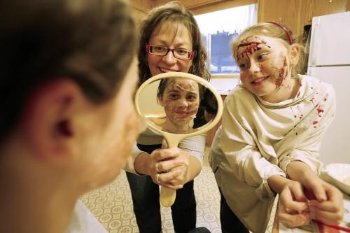 Emily Slater (10) checks her new look after Angela Fey, a woman who is an expert at doing gory makeup from ordinary kitchen ingredients,   and her friend Emily Dahl (9) applied makeup to her in Fey's kitchen on Friday, October 15, 2010.    Winnipeg Free Press/John Woods