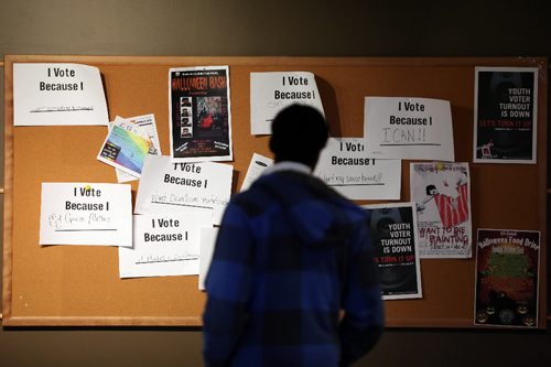 Brandon Sun 26102010 BU student Isaac Aghahon looks over a bulletin board filled with posters encouraging students to vote in Brandon's municipal election on Tuesday. (Tim Smith/Brandon Sun)