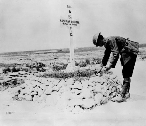 FILE-- A First World War soldiers places stones on a Canadian grave near Vimy, France in this June, 1917 archive photo. The fresh memory of soldier deaths in Afghanistan might suggest that canadians have largely forgotten a military history that embraces more than 100,000 war dead over the last century.  (CP PHOTO/National Archives of Canada)