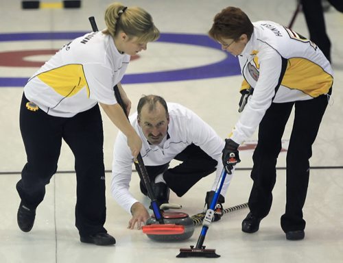 Sports- ( see Al's story)   -   Team Manitoba Second  Allan Lawn throws, center, as lead Lisa Blixhaun, left, and Lana Hunter, right , sweep at the 2011 Canadian Mixed Curling Championships Sunday afternoon at the Morris Curling Club in Morris, Manitoba during a game against Team Ontario -  JOE BRYKSA/WINNIPEG FREE PRESS- Nov 14, 2010