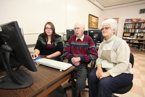 Brandon Sun 22112010 Community Access Program Intern Ebonie Becker shows Ed Gillis and Meryl Orth how to search for and download printable Christmas cards during a computer training session at Seniors for Seniors on Park Ave. East in Brandon on Monday. (Tim Smith/Brandon Sun)