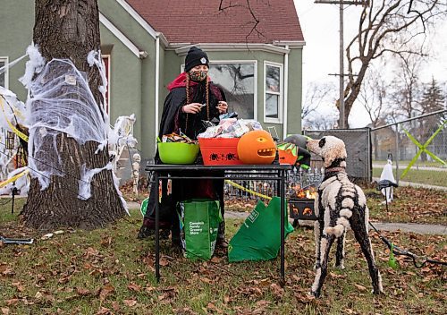 JESSICA LEE / WINNIPEG FREE PRESS

Jaclynne Green and her dog wait for children at their home in Elmwood on October 31, 2021. She and her partner have prepackaged their treats for neighbourhood children and decorated their house a few weeks before Halloween. 










