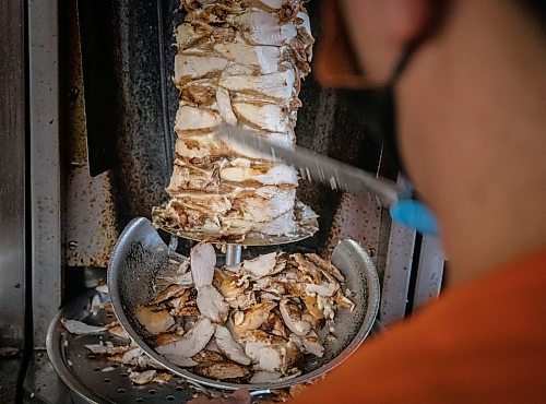 JESSICA LEE / WINNIPEG FREE PRESS

Badis Maymoni carves off chicken which spins on the spit at Baraka Bakery on November 10, 2021.







