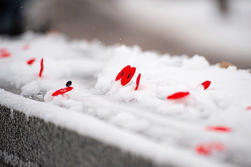 Mike Sudoma / Winnipeg Free Press
Poppy&#x2019;s lay in the snow on top of the Stone of Remembrance during a Remembrance Day service at Brookside Cemetery Thursday morning
November 11, 2021