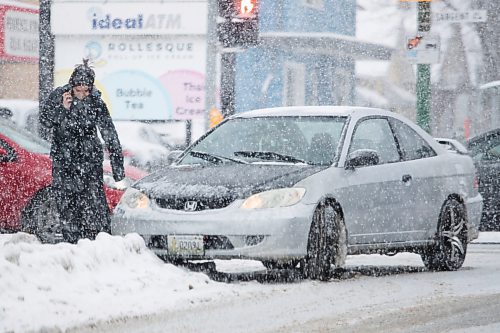 Daniel Crump / Winnipeg Free Press. A person calls for assistance after their vehicle hits the curb at Arlington St. And Sargeant Ave. during a snowstorm in Winnipeg, Saturday afternoon. November 13, 2021.