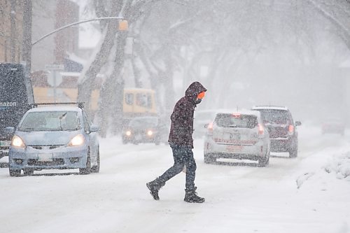 Daniel Crump / Winnipeg Free Press. A person crosses Westminster Ave. Saturday afternoon as heavy snow falls. November 13, 2021.