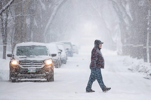 Daniel Crump / Winnipeg Free Press. A person crosses a street in Wolseley near Westminster Ave. Saturday afternoon as heavy snow falls. November 13, 2021.