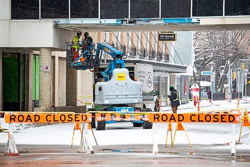 Daniel Crump / Winnipeg Free Press. Workers repair that skywalk at Portage Avenue and Donald Street. The damage was caused when a truck hit the pedestrian overpass just after midnight on Tuesday. November 17, 2021.