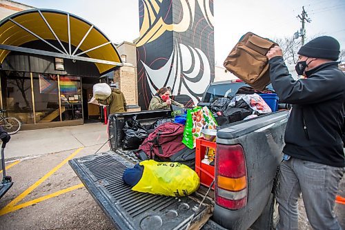 MIKAELA MACKENZIE / WINNIPEG FREE PRESS

Shannon St. Clair (left), and Marshall Wiebe, RaY staff member, unpack a pickup truck full of winter gear donations (from a memorial held last weekend for St. Clair's daughter) at RaY in Winnipeg on Friday, Nov. 26, 2021. For Kevin story.
Winnipeg Free Press 2021.