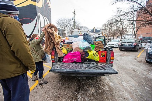 MIKAELA MACKENZIE / WINNIPEG FREE PRESS

Garth Coates, stepdad (left), and Shannon St. Clair, mother, unpack a pickup truck full of winter gear donations (from a memorial held last weekend for their daughter) at RaY in Winnipeg on Friday, Nov. 26, 2021. For Kevin story.
Winnipeg Free Press 2021.