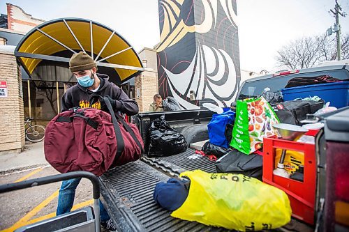 MIKAELA MACKENZIE / WINNIPEG FREE PRESS

Lolo Hillier, RaY employment training program member, unpacks a pickup truck full of winter gear donations (from a memorial held last weekend for Cassandra Sky Woodhouse-Braun-St. Clair) at RaY in Winnipeg on Friday, Nov. 26, 2021. For Kevin story.
Winnipeg Free Press 2021.