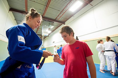 Mike Sudoma / Winnipeg Free Press
Olympic Bronze medalist, Catherine Beauchemin-Pinard, shows student, Owen Bevan her olympic bronze medal at the Judo Manitoba Training Centre prior to a training session Friday evening
November 26, 2021