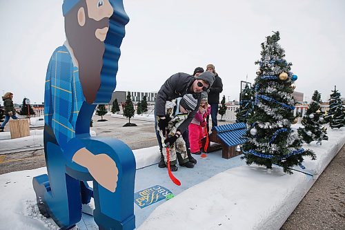 JOHN WOODS / WINNIPEG FREE PRESS
Michael Rathwell helps his son Liam as his cousin, Avery, and grandmother, Susan, and grandfather, Ward, look on at the Frozen Fairways attraction in the Polo Park parking lot in Winnipeg on Sunday, November 28, 2021. 

Re: standup
