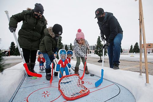 JOHN WOODS / WINNIPEG FREE PRESS
Meghan and Nathan Scarff, play with their children Hazel and Nolan, at the Frozen Fairways attraction in the Polo Park parking lot in Winnipeg on Sunday, November 28, 2021. 

Re: standup