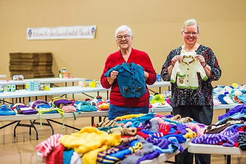 MIKAELA MACKENZIE / WINNIPEG FREE PRESS

Margaret Young, long-time knitting volunteer (left), and Janet Ammeter, church office administrator (who helps with yarn distribution and such), pose for a portrait with the knitting gathered for the Christmas Cheer Board at Charleswood United Church in Winnipeg on Thursday, Dec. 2, 2021. For Janine story.
Winnipeg Free Press 2021.