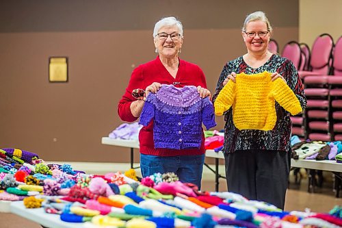 MIKAELA MACKENZIE / WINNIPEG FREE PRESS

Margaret Young, long-time knitting volunteer (left), and Janet Ammeter, church office administrator (who helps with yarn distribution and such), pose for a portrait with the knitting gathered for the Christmas Cheer Board at Charleswood United Church in Winnipeg on Thursday, Dec. 2, 2021. For Janine story.
Winnipeg Free Press 2021.