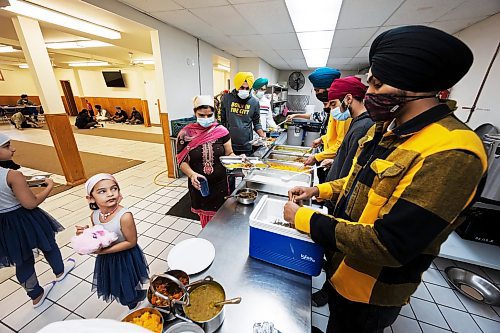 PRABHJOT SINGH / WINNIPEG FREE PRESS

A girl looks on while a volunteer waits to serve the devotees.
In the community kitchen of Gurdwara Singh Sahab on Sturgeon Road in Winnipeg, a five-course meal is prepared by a host of Sikh devotees for the weekly Sunday langar.

