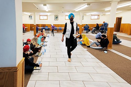 PRABHJOT SINGH / WINNIPEG FREE PRESS

A volunteer walks towards the kitchen as he finishes serving bread.
In the community kitchen of Gurdwara Singh Sahab on Sturgeon Road in Winnipeg, a five-course meal is prepared by a host of Sikh devotees for the weekly Sunday langar.

