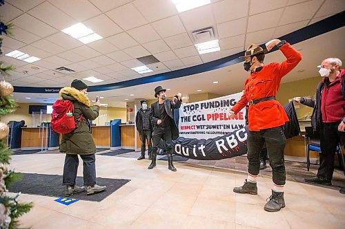 MIKAELA MACKENZIE / WINNIPEG FREE PRESS

Manitoba Energy Justice Coalition members perform a skit for a live video during a sit-in in support of the Wet'suwet'en at a downtown RBC bank in Winnipeg on Friday, Dec. 10, 2021. The group is calling for funders of the Coastal Gaslink pipeline to withdraw their support. Standup.
Winnipeg Free Press 2021.