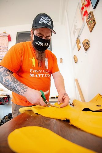 Mike Sudoma / Winnipeg Free Press
Keith Proulx, Owner of Cree Ations and Artist Showcase, cuts out a pattern for moccasins in his shop/workshop on Main St Monday afternoon
December 13, 2021 