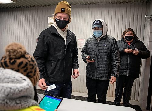 JESSICA LEE / WINNIPEG FREE PRESS

Darren Gisti (second from left) has his vaccination status checked before being allowed entry into Selkirk Recreation Complex for a hockey game on December 17, 2021.














