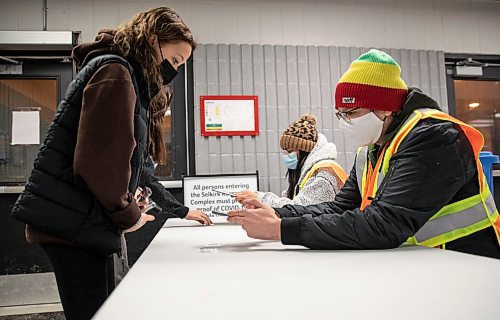 JESSICA LEE / WINNIPEG FREE PRESS
Alysha Shofield (left) shows her vaccination card to Taylor Sinclair (right) before being allowed entry into Selkirk Recreation Complex for a hockey game on December 17, 2021.