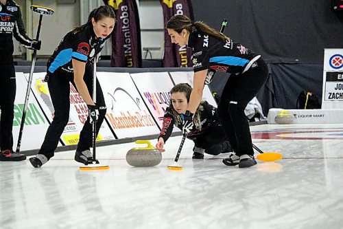 Karlee Burgess, left, and Emily Zacharias prepare to sweep a rock thrown by their skip Mackenzie Zacharias during a game at the 2022 Manitoba Scotties Tournament of Hearts in Carberry Saturday. (Lucas Punkari/The Brandon Sun)