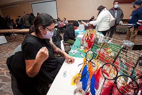 Mike Sudoma / Winnipeg Free Press
Artist, Carey Sinclair, works on a pair of earrings as she works sits at her booth at the Indigenous Arts Market at Canad Inns Polo Park Sunday morning
December 19, 2021 