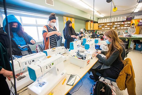 MIKAELA MACKENZIE / WINNIPEG FREE PRESS

Rebecca Chambers (centre, striped shirt) helps grade 11/12 students make jeans during textiles class at Shaftesbury High School in Winnipeg on Wednesday, Dec. 22, 2021. For Maggie story.
Winnipeg Free Press 2021.