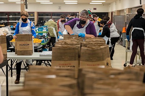 Debbie Medwechuk bags free holiday meals for Westman and Area Traditional Christmas Dinner deliveries Saturday at Crocus Plains Regional Secondary School. (Chelsea Kemp/The Brandon Sun)